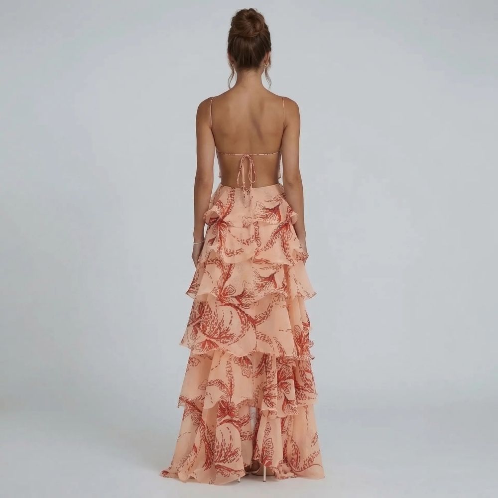 Peach tiered ruffle maxi dress with open-back tie detail and flowing printed skirt — back view.