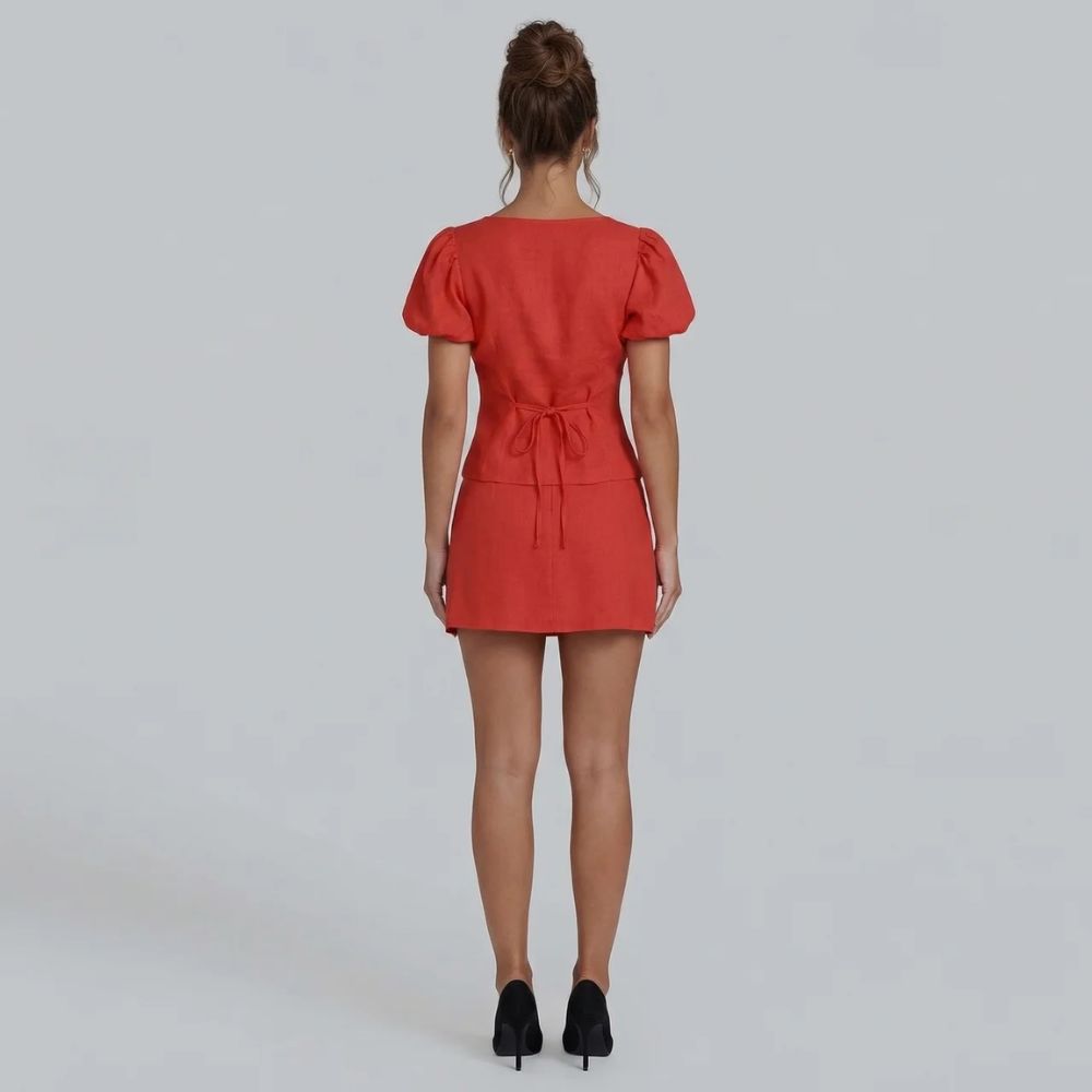 Rear shot of red puff sleeve tie blouse and mini skirt set.