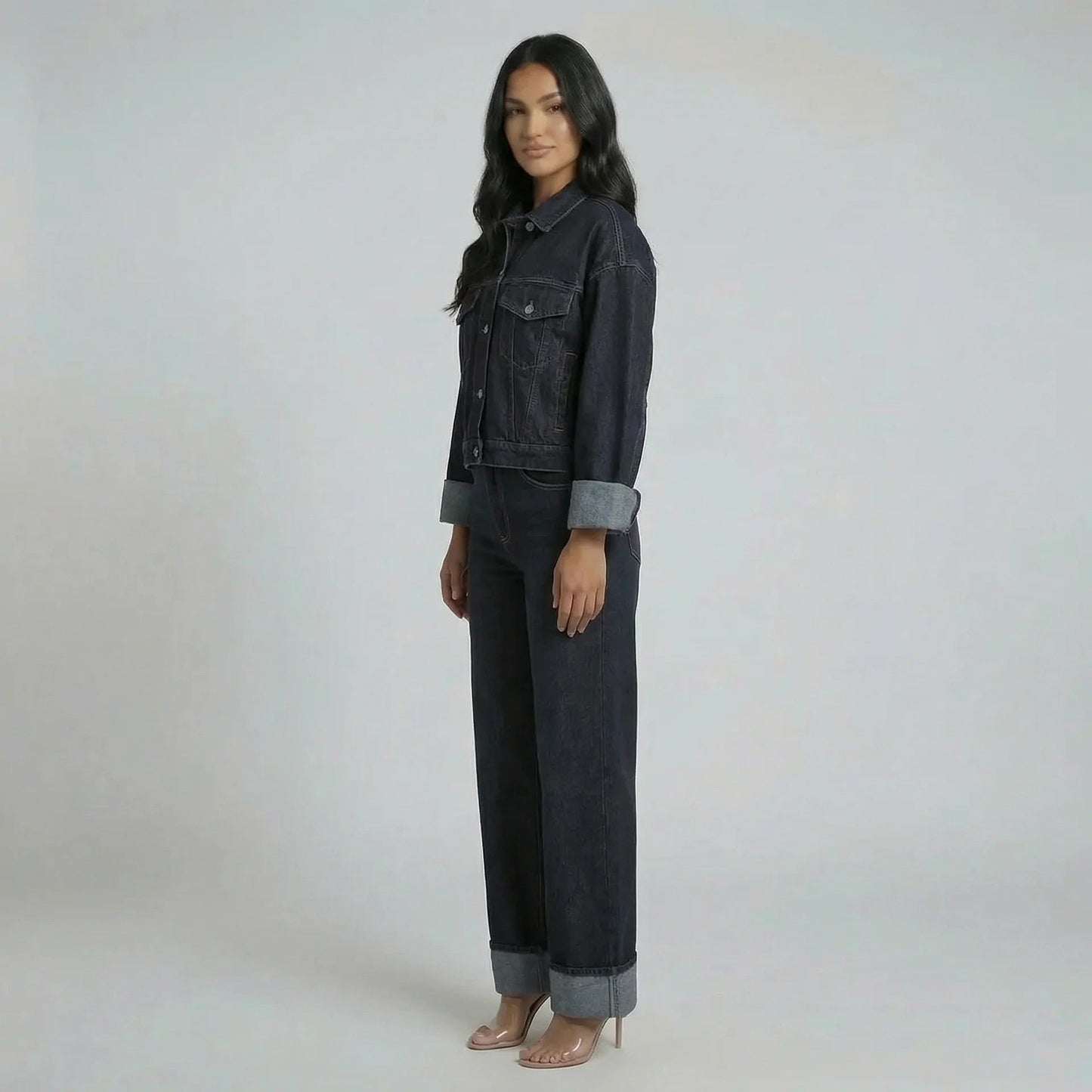 Side profile of the cropped jacket showing lapel-notched neckline and cuffed sleeves, paired with structured jeans.