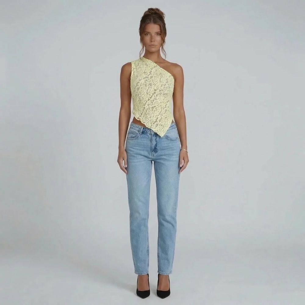Cream floral lace asymmetric one-shoulder top with handkerchief hem — front view styled with blue jeans.