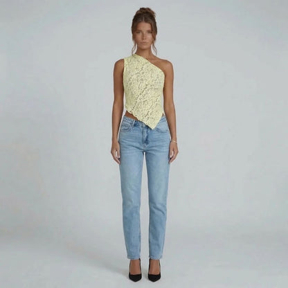 Cream floral lace asymmetric one-shoulder top with handkerchief hem — front view styled with blue jeans.