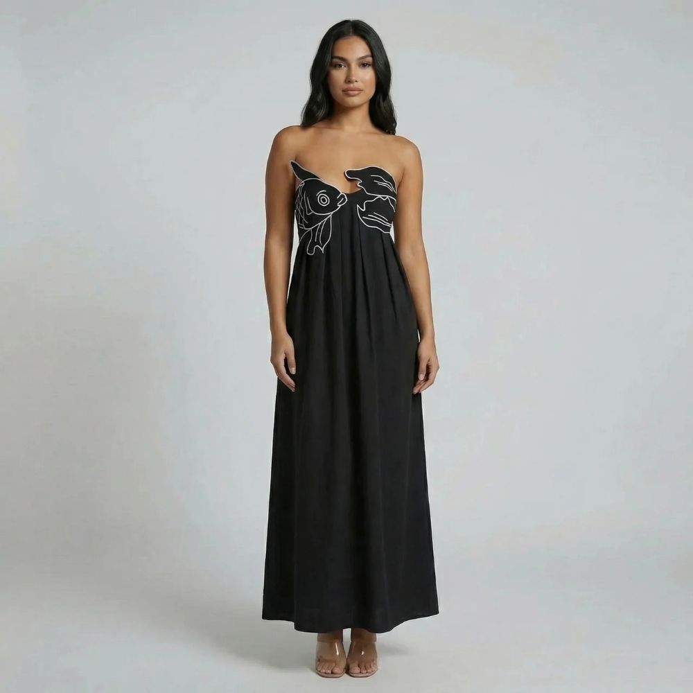 Black graphic maxi dress with flowy skirt and spaghetti straps, styled full-length shot.