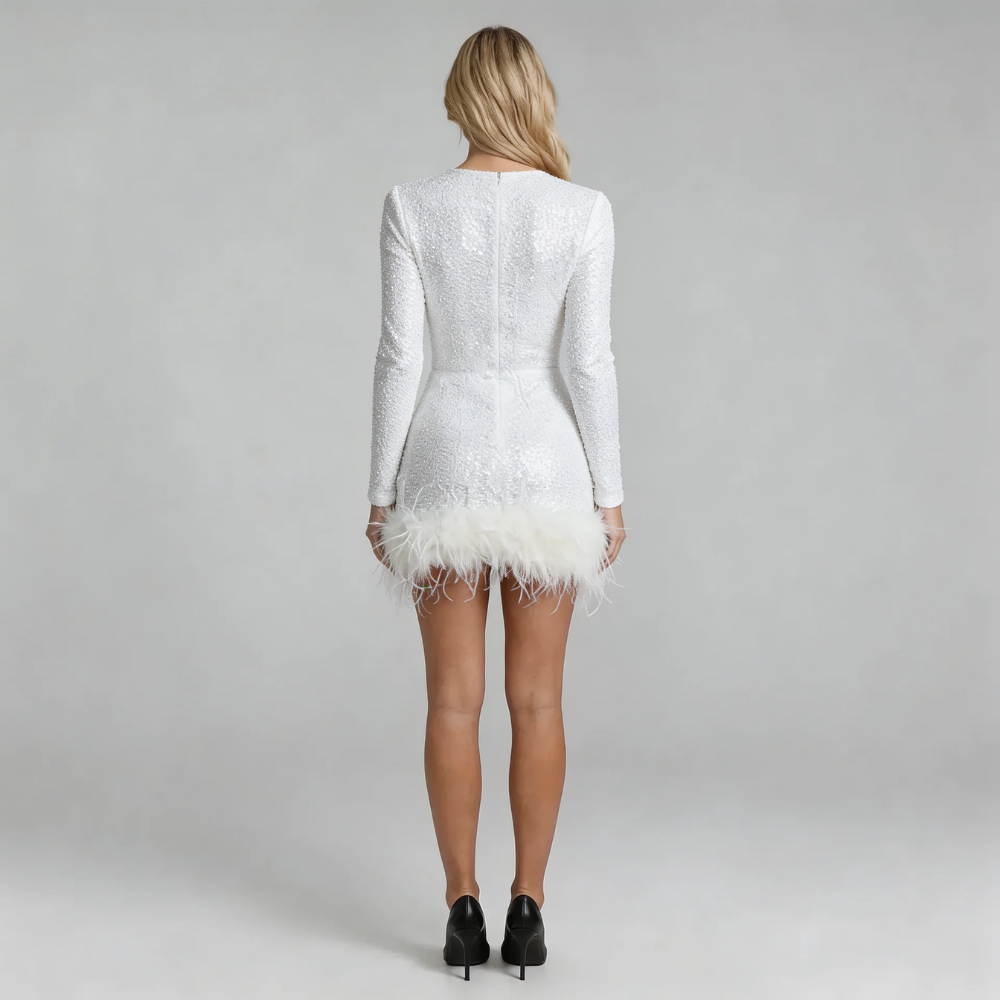 White sequin mini dress with feather-trim hemline — back view showing zip closure and sleek silhouette.