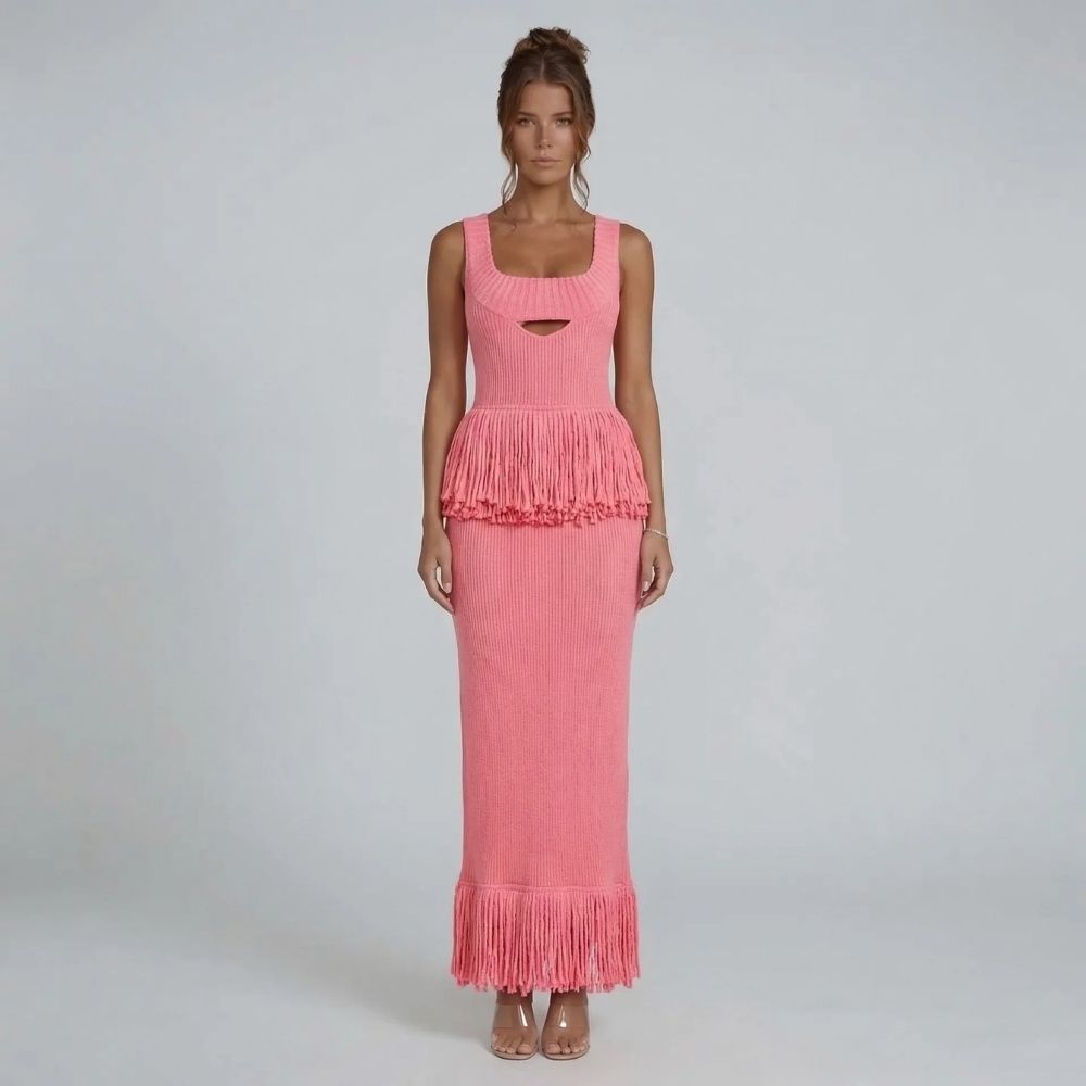 Pink ribbed-knit fringe maxi dress with square neckline — front view highlighting fringe detail at the waist and hem.