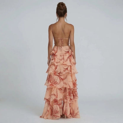 Peach tiered ruffle maxi dress with open-back tie detail and flowing printed skirt — back view.