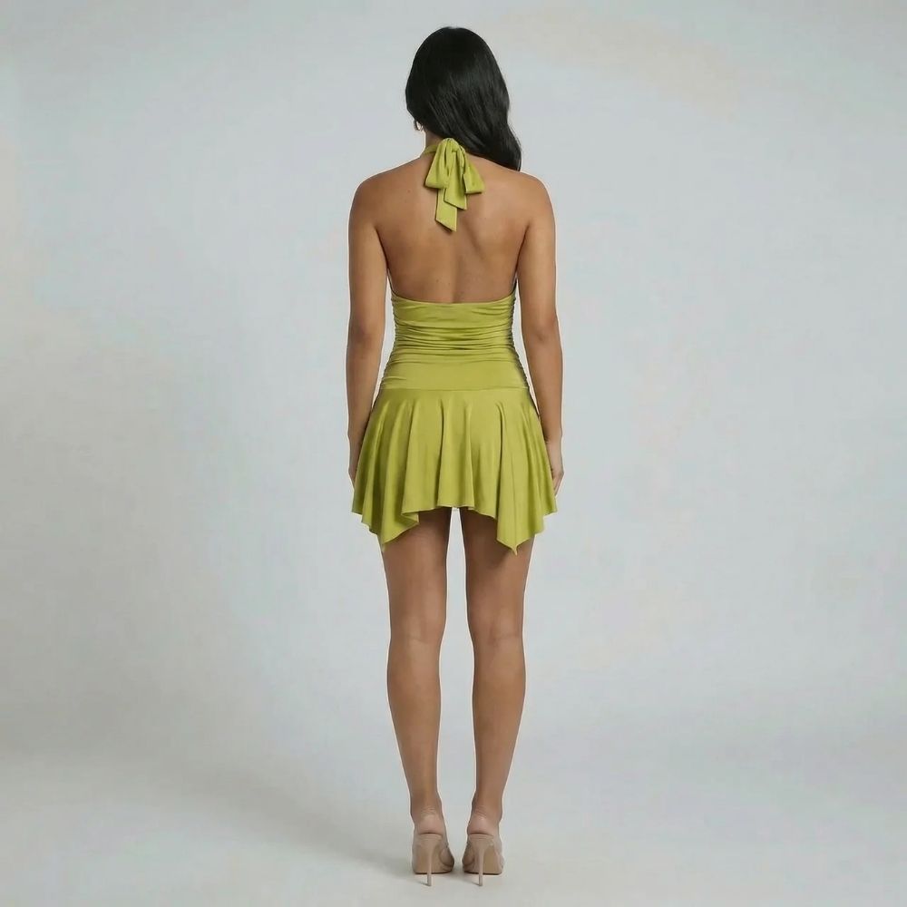 Open-back sage mini dress with adjustable halter tie and flowy hem — back view showcasing bow detail.