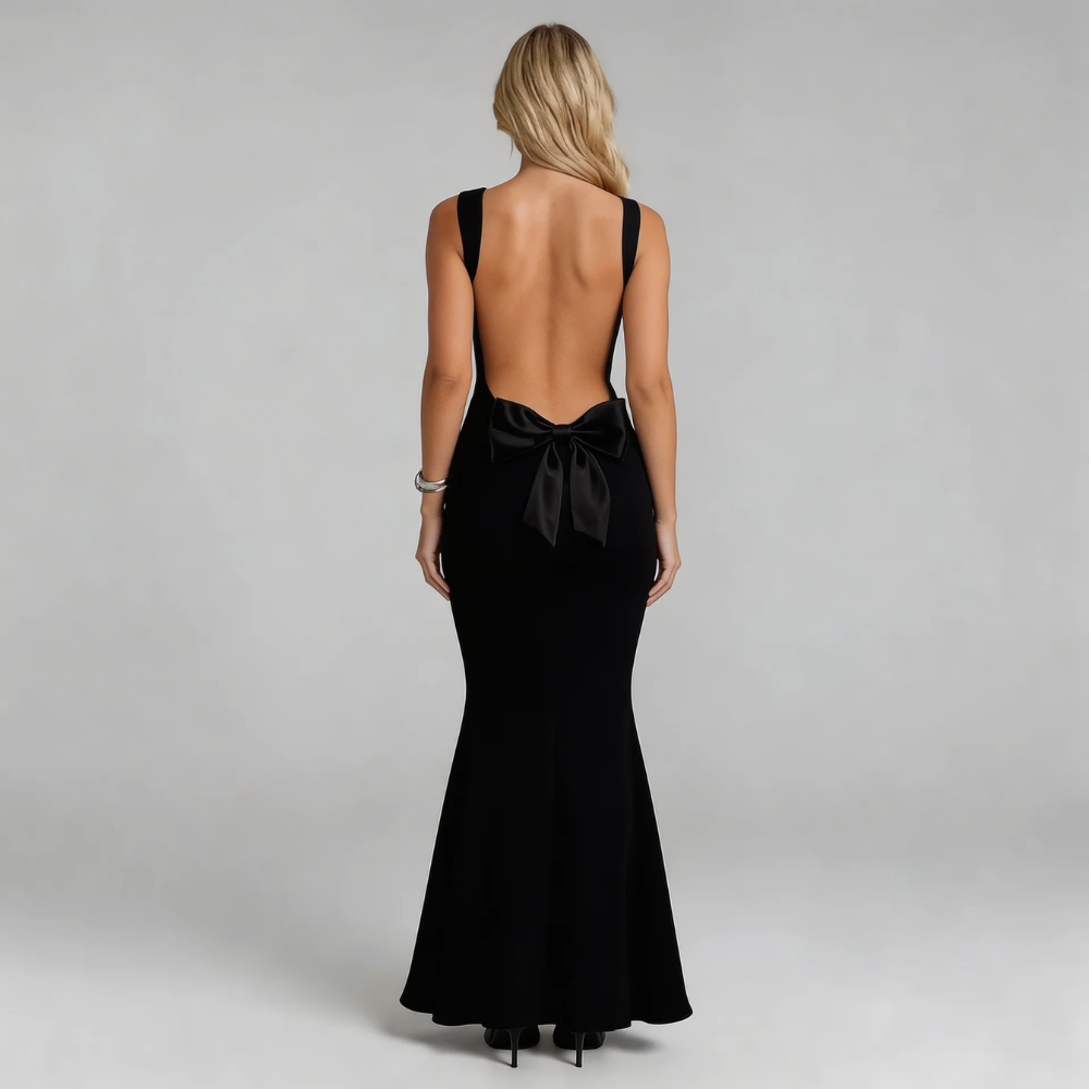 Black maxi dress featuring oversized back bow and dramatic open-back design — back view.