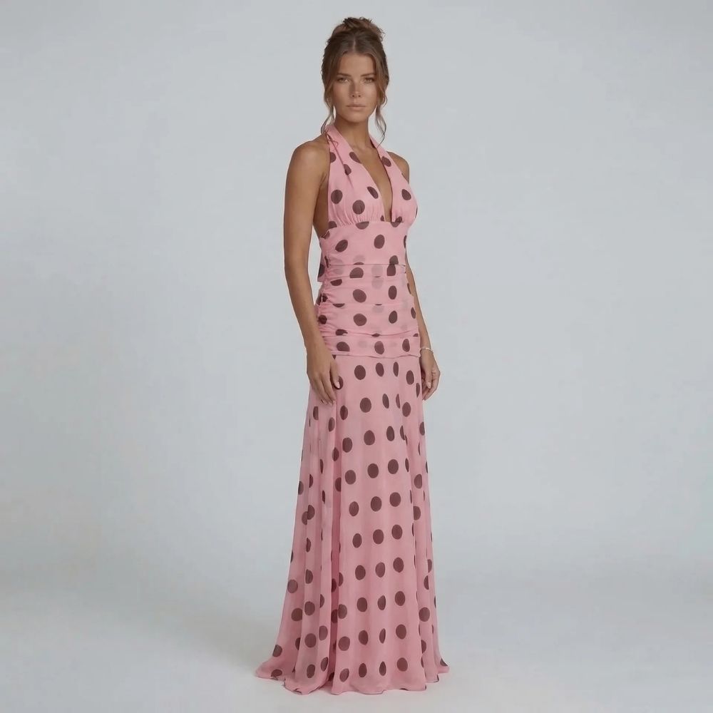 Pink polka dot maxi dress with halter neckline — front view showcasing ruched waistline and flowing skirt.