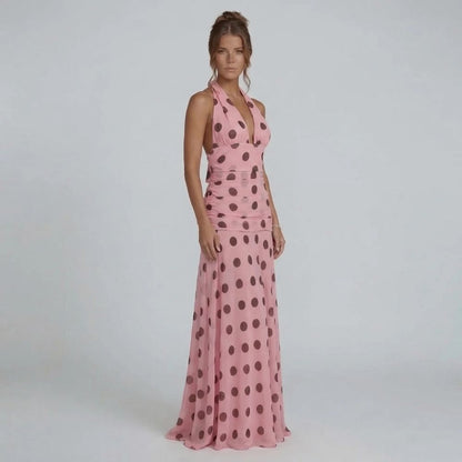 Pink polka dot maxi dress with halter neckline — front view showcasing ruched waistline and flowing skirt.