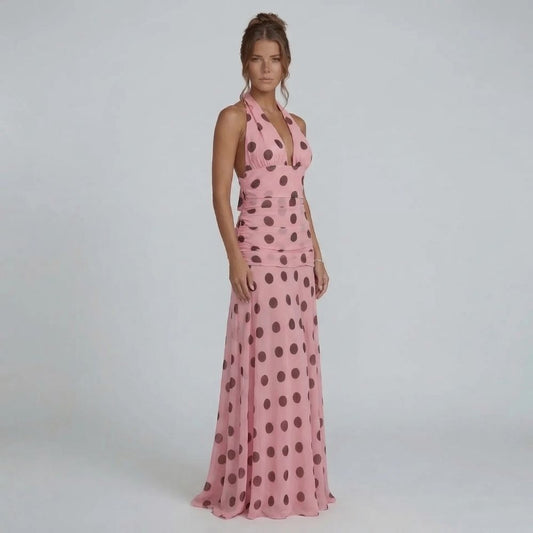 Pink polka dot maxi dress with halter neckline — front view showcasing ruched waistline and flowing skirt.