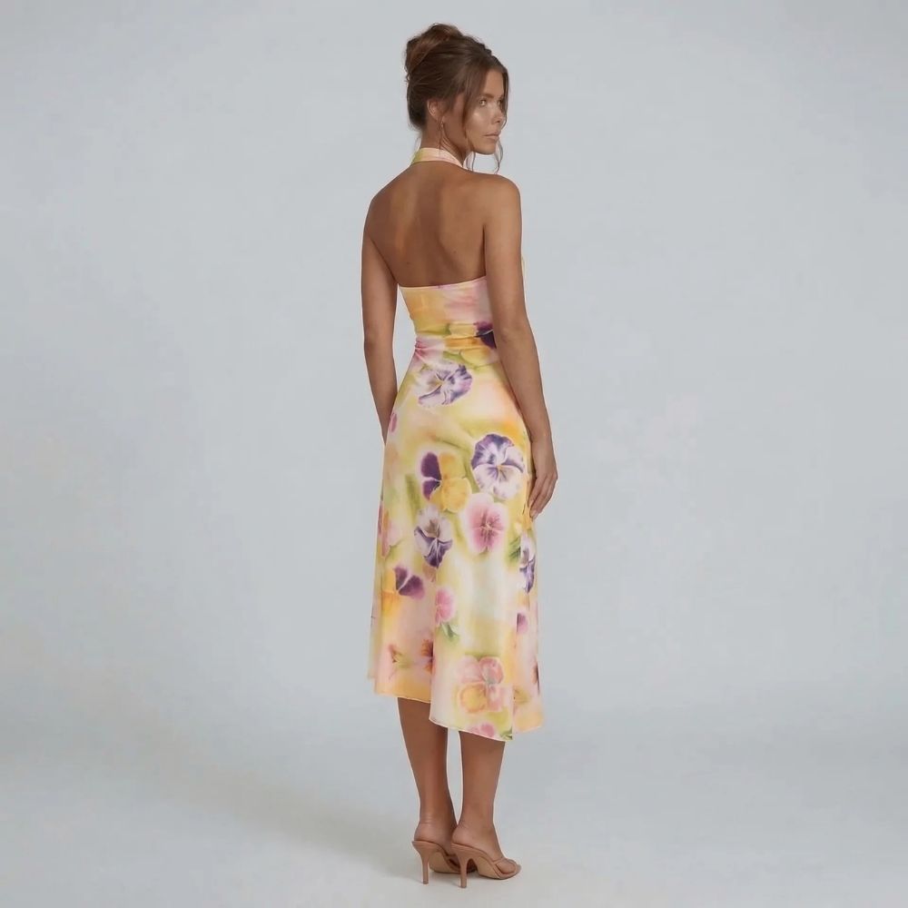 Cream floral halter midi dress with asymmetrical wrap skirt — back view showcasing open-back design and watercolor pattern.