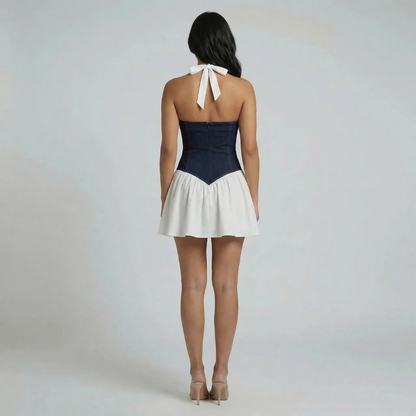 White and navy corset mini dress — back view featuring tie neck detail and flared A-line skirt.