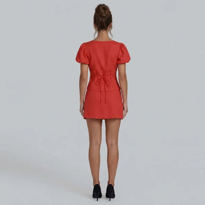Rear shot of red puff sleeve tie blouse and mini skirt set.