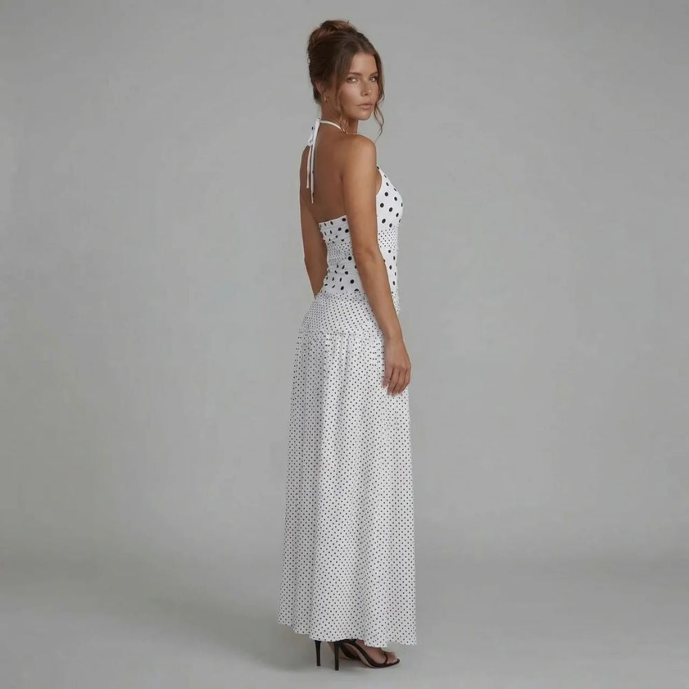 White polka dot maxi dress — back view featuring halter tie closure and flowing asymmetric hem.