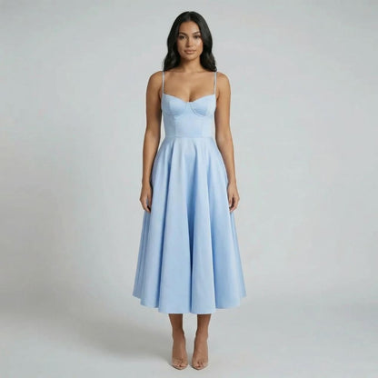 Light blue fit-and-flare midi dress with corset-style bodice — styled with neutral accessories.