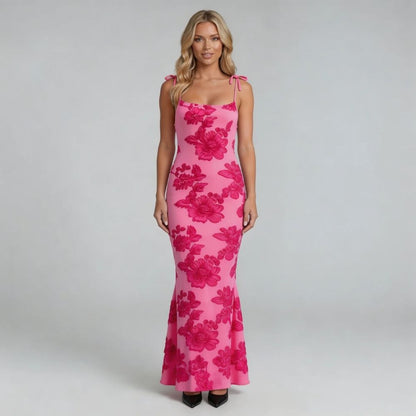 White floral maxi dress with adjustable tie shoulder straps — close-up view showcasing bow details.