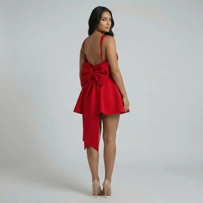 Back view of red mini dress showcasing detachable oversized bow detail