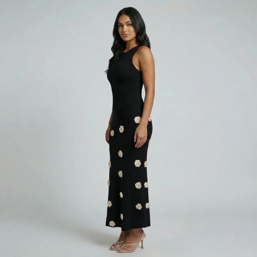 Black maxi dress with 3D floral appliqués—side view highlighting sleek silhouette.