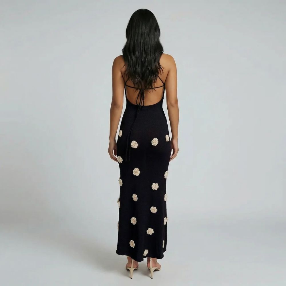 Black maxi dress with lace-up open back and floral details—back view showcasing design.