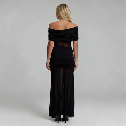 Black mesh maxi dress — back view showing draped off-shoulder design and floor-length silhouette.
