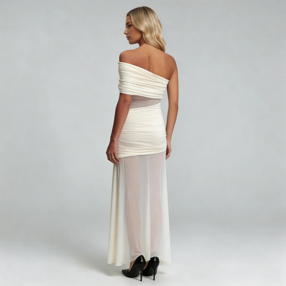 White mesh maxi dress — back view showing draped one-shoulder neckline and flowing skirt.