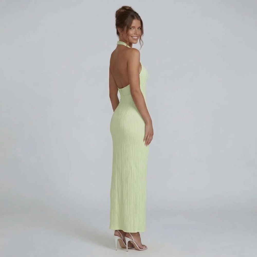 Green pleated maxi dress with open back — side angle highlighting backless silhouette.
