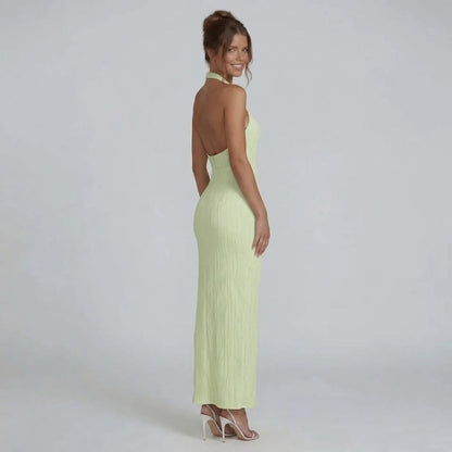 Green pleated maxi dress with open back — side angle highlighting backless silhouette.