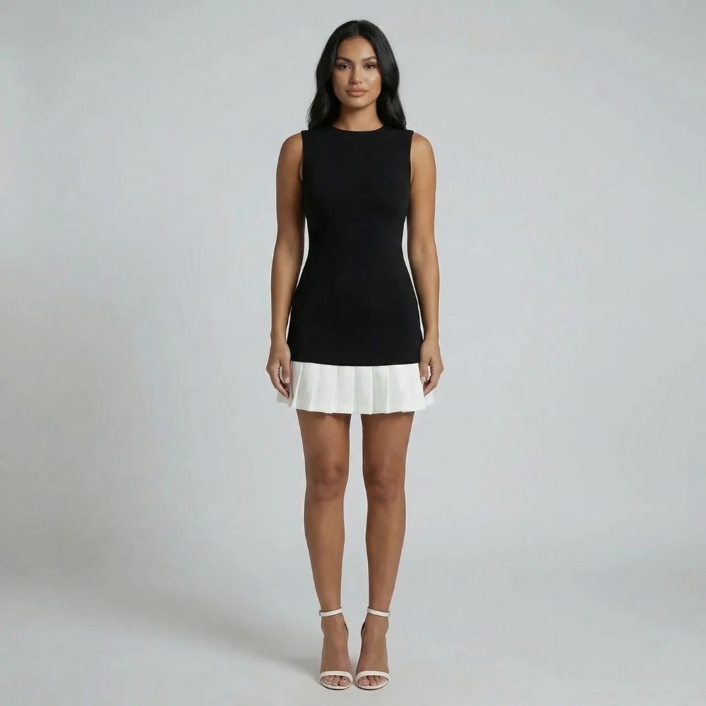 Black and white mini dress with pleated hem — full front view showing structured silhouette.