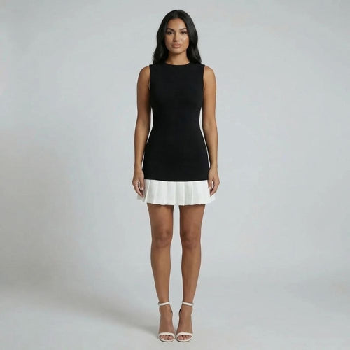 Black and white mini dress with pleated hem — full front view showing structured silhouette.