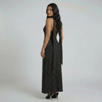 Black polka-dot maxi dress with open back and scarf-neck — side view emphasizing back detail