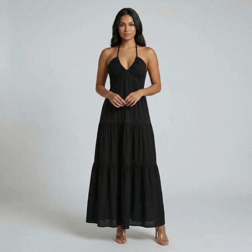 Black tiered maxi dress — front view with halter neckline and flowing silhouette styled with neutral heels.