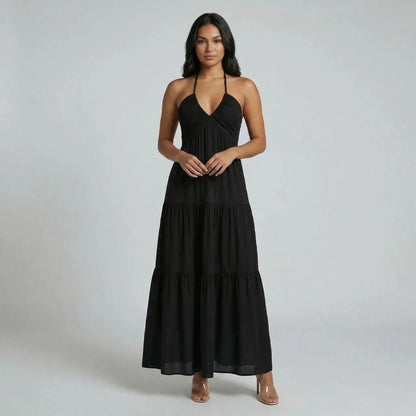 Black tiered maxi dress — front view with halter neckline and flowing silhouette styled with neutral heels.