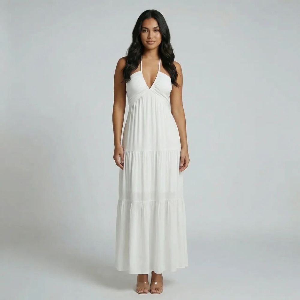 White tiered maxi dress with halter neckline — front view showing flowing skirt and deep V neckline.