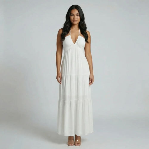White tiered maxi dress with halter neckline — front view showing flowing skirt and deep V neckline.