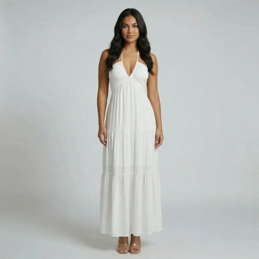 White tiered maxi dress with halter neckline — front view showing flowing skirt and deep V neckline.