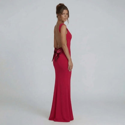 Red bow-back maxi dress with open-back design and oversized bow — side view detail.