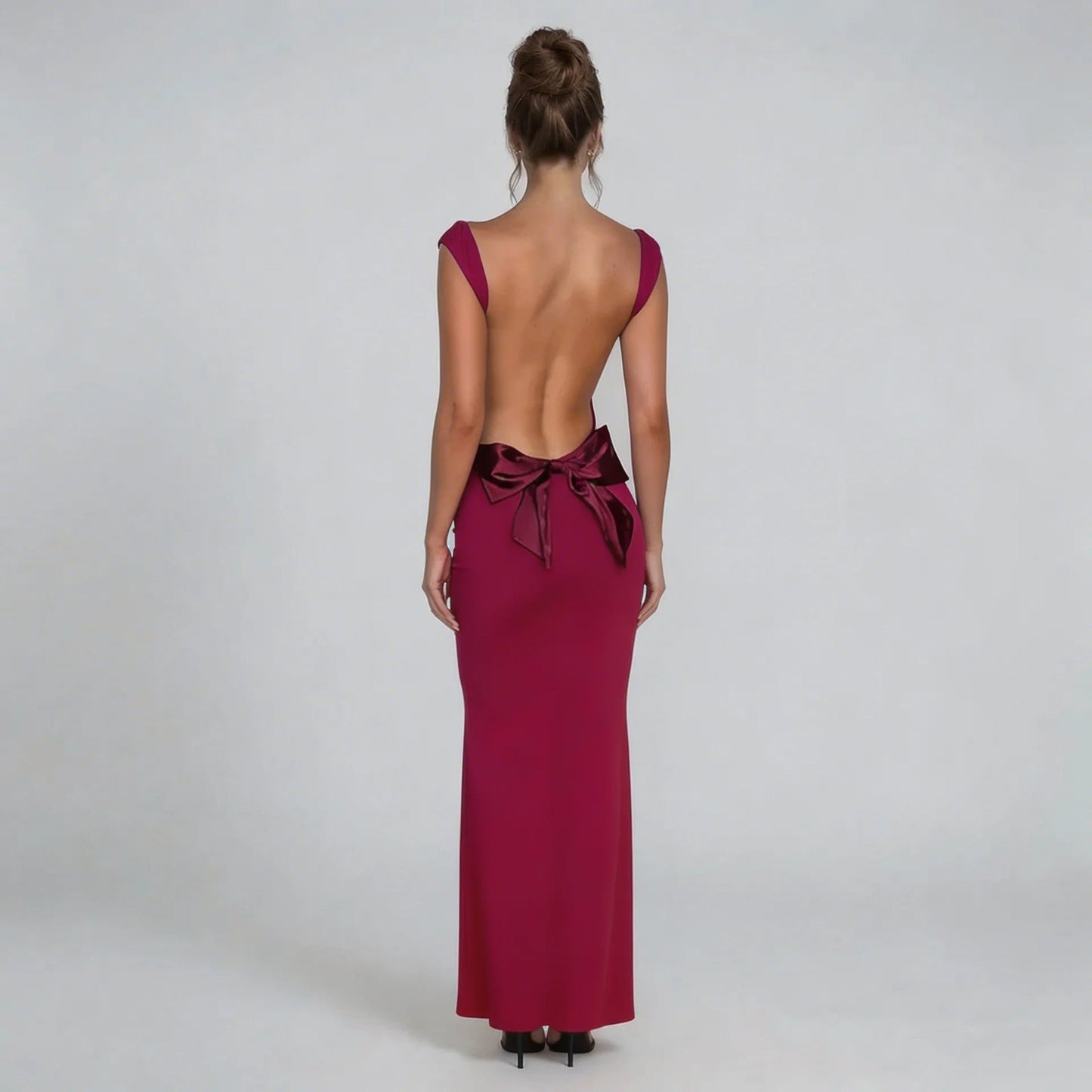 Red bow-back maxi dress showcasing a full open-back design and oversized bow — back view.