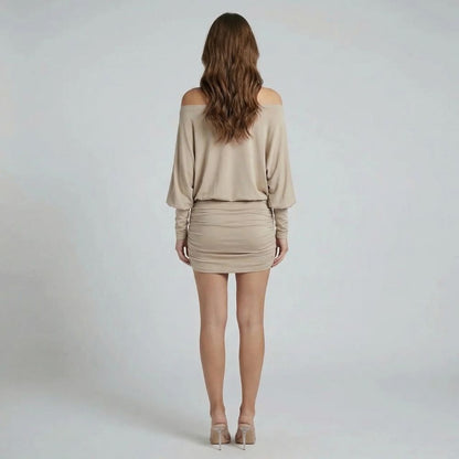 Black ruched mini dress with off-shoulder neckline and long cuffed sleeves — angled view of the design.
