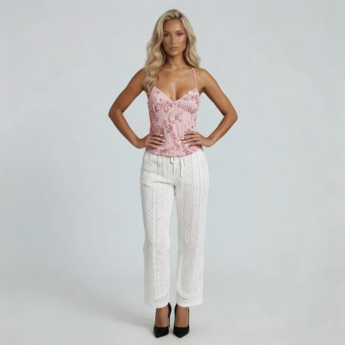 Women pink sequin cami top with spaghetti straps and beaded fringe detail, paired with white eyelet pants