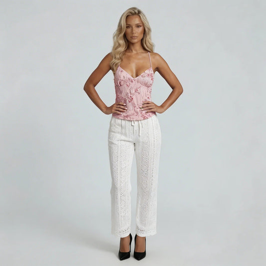 Women pink sequin cami top with spaghetti straps and beaded fringe detail, paired with white eyelet pants