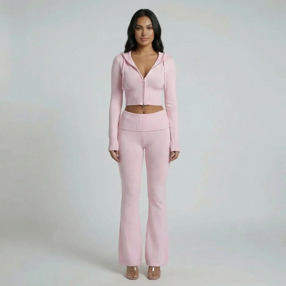 Light pink ribbed knit lounge set featuring a cropped zip-up hoodie and high-waisted flared pants — front view.