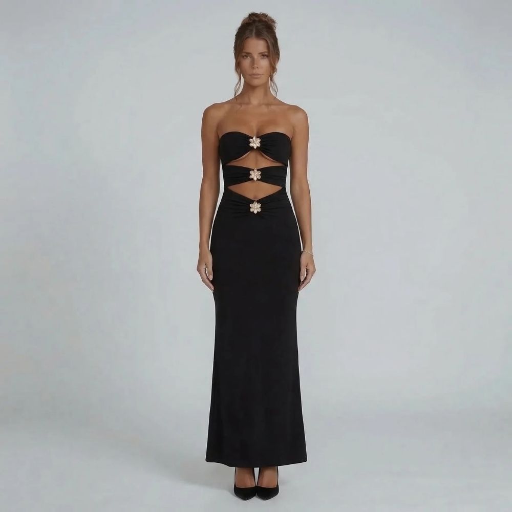 Black strapless maxi dress with bold cutouts and gold floral hardware accents — front view