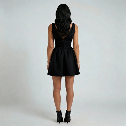 Black corset-style mini dress — back view showing zipper detail and flared silhouette.