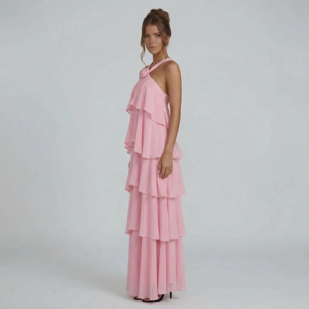 Side profile of a pink Rosalie ruffled maxi dress, showcasing the tiered layers and halter neckline.