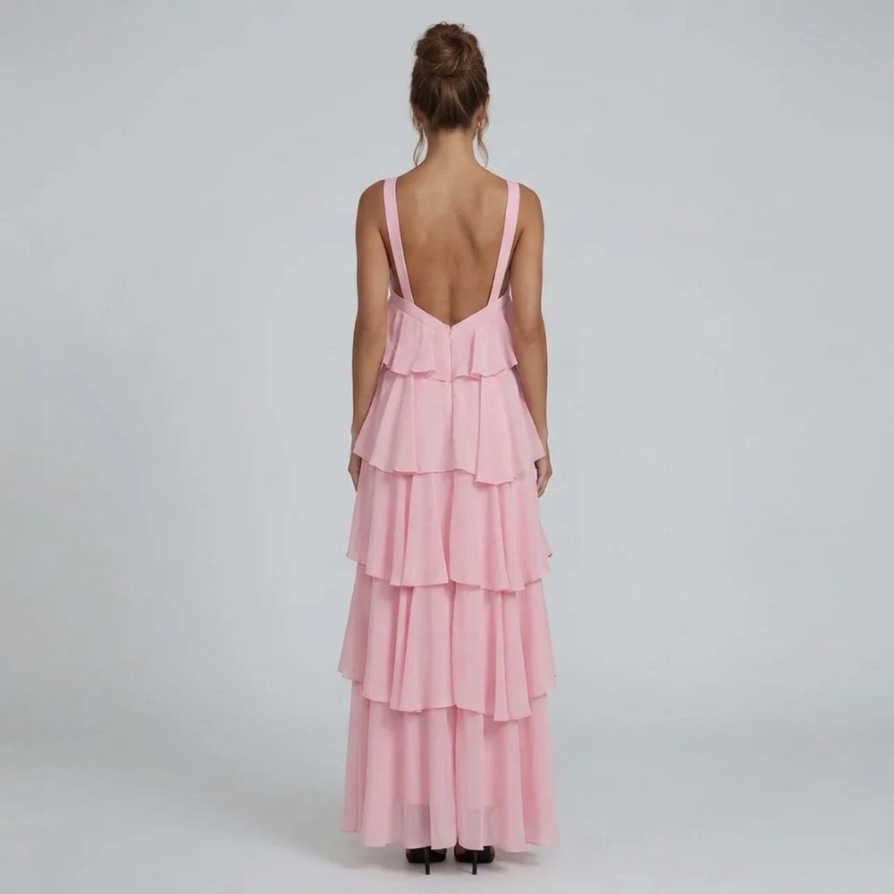 Back view of the pink ruffled maxi dress, featuring a low back design and tiered skirt details.