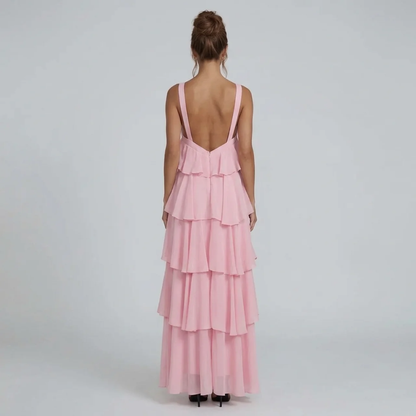 Back view of the pink ruffled maxi dress, featuring a low back design and tiered skirt details.