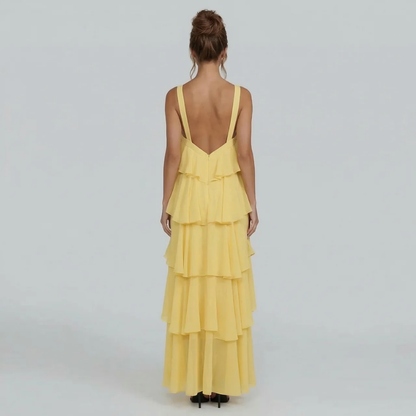 Back view of the yellow ruffled maxi dress, displaying the elegant open back and full tiered skirt.