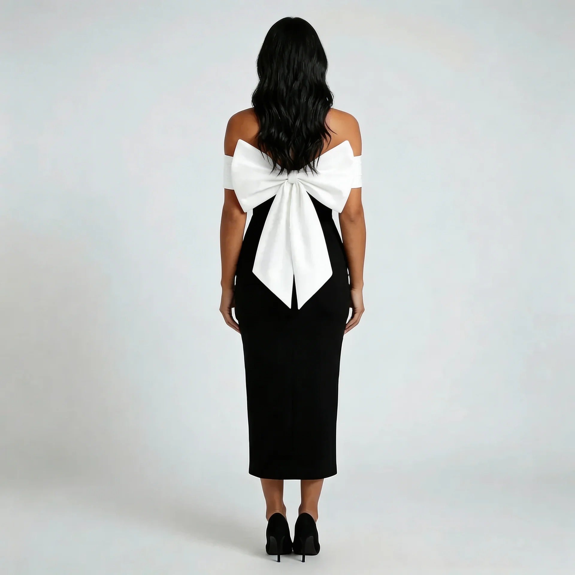 Black off-shoulder midi dress with oversized white bow detail — back view highlighting dramatic bow.