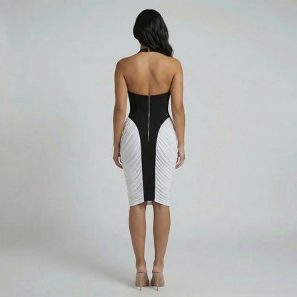 Black halter midi dress with zip-back closure and asymmetric white panels — back view highlighting open back.