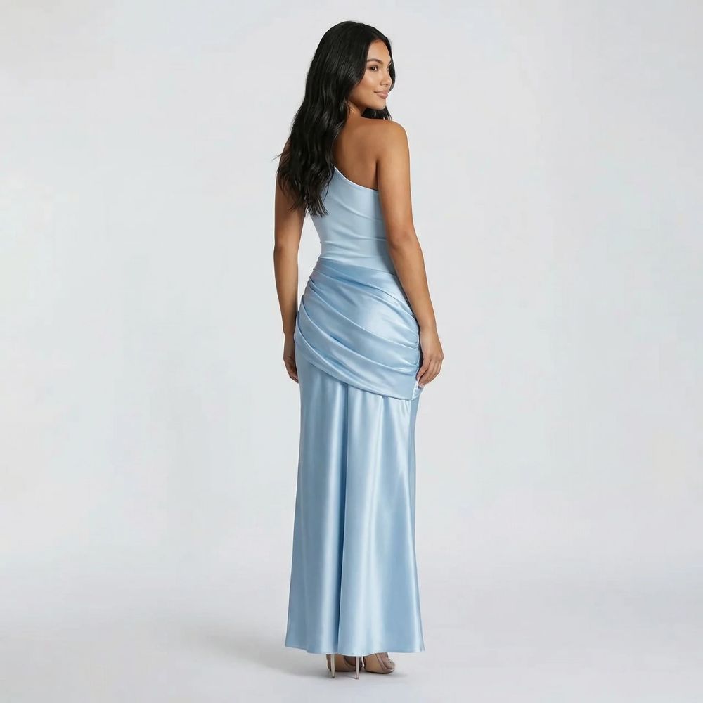 Light blue maxi dress with one-shoulder neckline — back view displaying draped overlay detail and sleek fit.